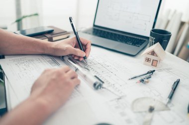 Mimar mühendis, bueprint üzerinde çalışırken kalem ve mini T-slide tasarımı kullanır. Ev planlama ve inşaat konsepti.