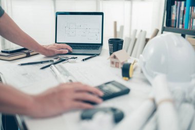 Mimar mühendis çek çizimi için dizüstü bilgisayar kullanır. Ev planlama ve inşaat konsepti.