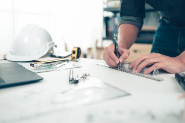 Mimar mühendis, bueprint üzerinde çalışırken kalem ve mini T-slide tasarımı kullanır. Ev planlama ve inşaat konsepti.