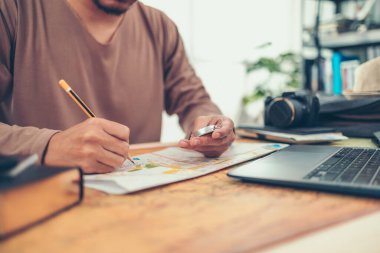 Seyahat etmeden önce yol haritalarını ve dünya haritalarını kontrol eden bir adam. Seyahat, macera ve keşif konsepti.