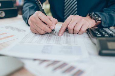 Muhasebeci şirket verilerinde, belgelerde ya da masa başında numaraya işaret ediyor. Muhasebe iş konsepti.
