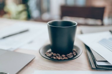 Ofis masasında bir fincan kahve ve şirket verileri, belge ve rapor masanın üzerinde. Muhasebe iş konsepti.