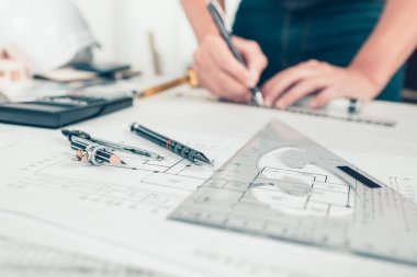 Mimar mühendis, plan üzerinde çalışırken kalem, üçgen açı cetvel ve pusula kullanır. Ev planlama ve inşaat konsepti.