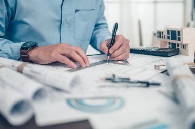 Mimar mühendis, plan üzerinde çalışırken kalem ve açı koruyucu çizim kullanıyor. Ev planlama ve inşaat konsepti.