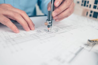 Mimar mühendisi, plan üzerinde çalışan pusula çizimi kullanır. Ev planlama ve inşaat konsepti.