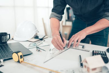 Mimar mühendis, plan üzerinde çalışırken kalem ve açı koruyucu çizim kullanıyor. Ev planlama ve inşaat konsepti.