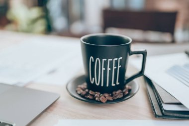 Ofis masasında bir fincan kahve ve şirket verileri, belge ve rapor masanın üzerinde. Muhasebe iş konsepti.