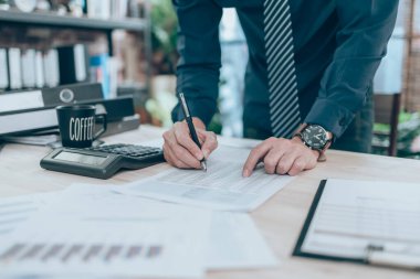 Masa başında hesaplamak için şirket verileri, belgeleri, raporları ve hesap makineleri üzerinde çalışan muhasebeci. Muhasebe iş konsepti.