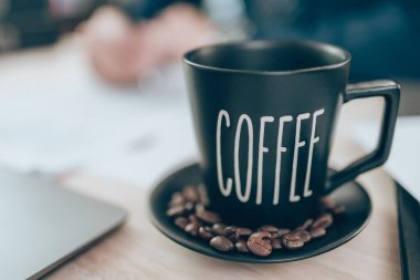 Ofis masasında bir fincan kahve ve hesap makinesi üzerinde çalışan muhasebeci şirket verilerini, belgelerini ve raporlarını masabaşında hesaplıyor. Muhasebe iş konsepti.