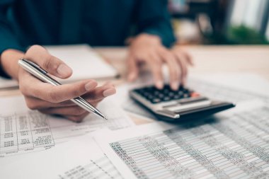 Masa başında çalışan yatırımcılar denge, projeksiyon, para ve maliyeti hesaplamak için hesap makinesi kullanıyorlar. Muhasebe ve Finans kavramı.