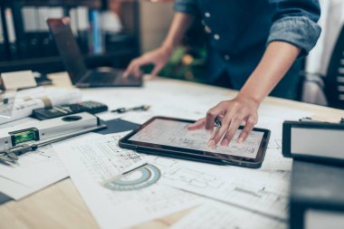 Mimar mühendis çizim tasarımını okumak için tablet kullanır. Ev planlama ve inşaat konsepti.