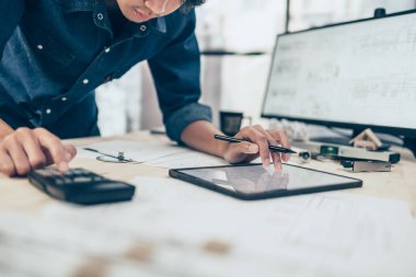 Mimar mühendis çizim tasarımını okumak için tablet kullanır. Ev planlama ve inşaat konsepti.