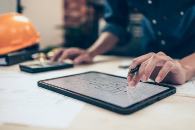 Mimar mühendis çizim tasarımını okumak için tablet kullanır. Ev planlama ve inşaat konsepti.