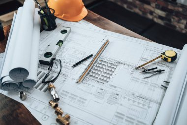 Mühendislik büro masası ve hesap makinesinde çizim teftişi, üçgen cetvel, güvenlik gözlükleri, pusula, planda daha düşük kalibre. Mühendis, Mimar, Endüstri ve Fabrika Konsepti.