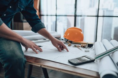 Mühendislik büro masası ve hesap makinesinde çizim teftişi, üçgen cetvel, güvenlik gözlükleri, pusula, planda daha düşük kalibre. Mühendis, Mimar, Endüstri ve Fabrika Konsepti.