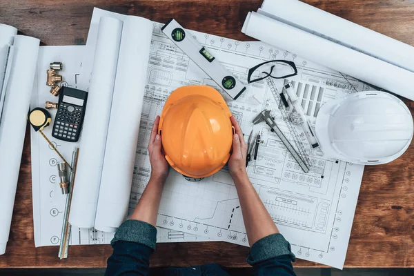 Engineering Hält Schutzhelm Mit Zeichnungen Inspektion Auf Dem Schreibtisch Und — Stockfoto