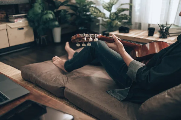 Молодой Человек Отдыхает Играет Гитаре Сидя Дома Диване Гостиной Концепция — стоковое фото