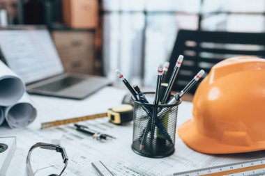 Ofis masası ve hesap makinesi, üçgen cetvel, güvenlik gözlüğü, pusula, plan üzerinde vernier kalibre. Mühendis, Mimar, Endüstri ve Fabrika Konsepti.