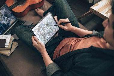 Seyahat planlayan gezginler otellerde rezervasyon yaptırmak, uçak bileti almak, arama haritası çıkarmak ya da evdeki oturma odasındaki kanepe yatağında seyahat yolları bulmak için tablet kullanıyorlar. Seyahat kavramı.