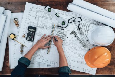 Üst Manzara Mühendisliği, çizim teftişi ve ofis masasında yazı, üçgen cetvel, güvenlik gözlüğü, pusula, mavi çizimde daha sade kalibre. Mühendis, Mimar, Endüstri ve Fabrika Konsepti.