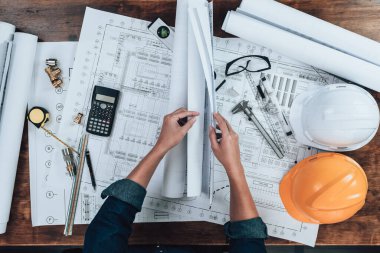 Üst Manzara Mühendisliği, ofis masası ve hesap makinesinde çizim teftişi, üçgen cetvel, güvenlik gözlüğü, pusula, Planlama 'da vernier kalibre. Mühendis, Mimar, Endüstri ve Fabrika Konsepti.