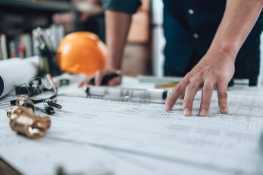 Mühendislik büro masası ve hesap makinesinde çizim teftişi, üçgen cetvel, güvenlik gözlükleri, pusula, planda daha düşük kalibre. Mühendis, Mimar, Endüstri ve Fabrika Konsepti.