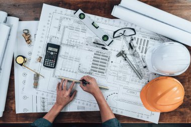 Üst Manzara Mühendisliği, çizim teftişi ve ofis masasında yazı, üçgen cetvel, güvenlik gözlüğü, pusula, mavi çizimde daha sade kalibre. Mühendis, Mimar, Endüstri ve Fabrika Konsepti.