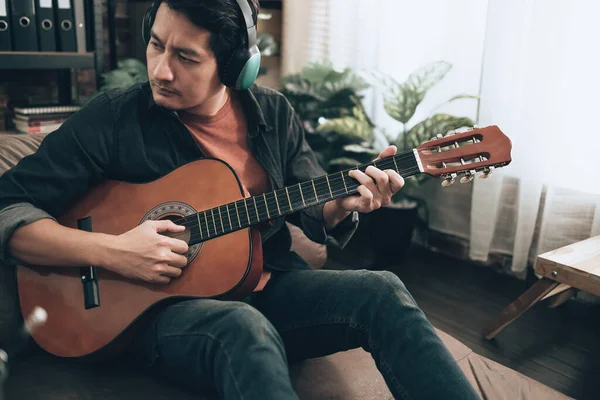 Молодий Чоловік Розслабляється Грає Гітарі Сидячи Дивані Вітальні Вдома — стокове фото