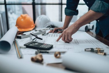 Mühendislik büro masası ve hesap makinesinde çizim teftişi, üçgen cetvel, güvenlik gözlükleri, pusula, planda daha düşük kalibre. Mühendis, Mimar, Endüstri ve Fabrika Konsepti.