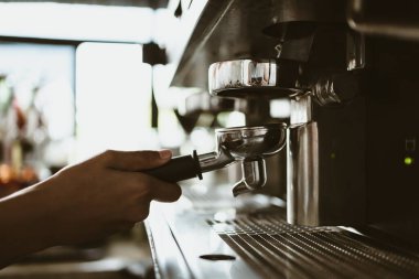 Kahveci dipsiz filtresi olan kahve makinesi kullanır. Kahve makinesi konsepti.