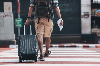 Turistler kalacak bir otel bulmak için bagajlarını yolda sürüklüyorlar. seyahat kavramı