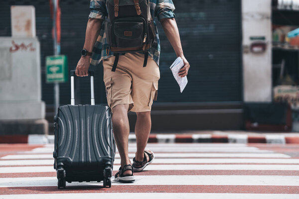Tourists drag their luggage on the road to find a hotel to stay. travel concept