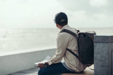 Turistler eğlence, restoran ya da otel bulmak için haritalar tutuyorlar. Sırt çantası ve seyahat kavramı.