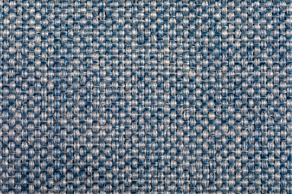 Blue fabric texture. Furniture upholstery textiles. Embossed pattern. Woven fibers. The material is soft touch. Minimalism concept. High detail macro photography for backgrounds or wallpapers.