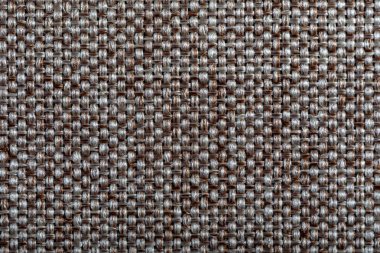 Kahverengi kumaş. Mobilya döşeme tekstili. Kabartmalı desen. Dokuma iplikleri. Malzeme yumuşak dokunuşlu. Minimalizm kavramı. Arkaplan ya da duvar kağıtları için yüksek detaylı makro fotoğrafçılık.