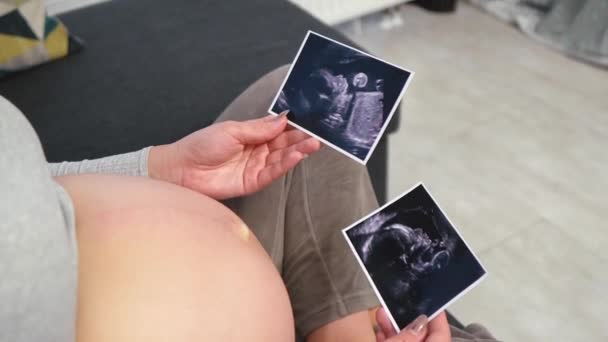 Беременная Женщина Удобной Одежде Сидит Полу Смотрит Ультразвуковое Фото Своего — стоковое видео
