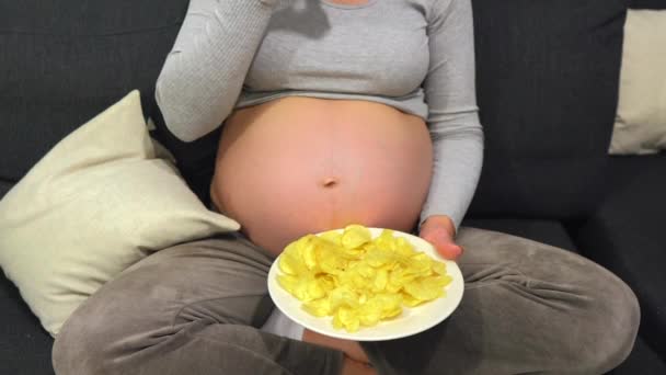 Αγνώριστη Γυναίκα Τρώει Ανθυγιεινά Πατατάκια Και Χαϊδεύει Έγκυο Κοιλιά Ανέμελη — Αρχείο Βίντεο