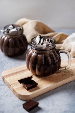 İki fincan aromalı sıcak çikolata ve mavi arka planda marşmelov. Samimi içkiyi kabul et. Ön görünüm ve kapatma.