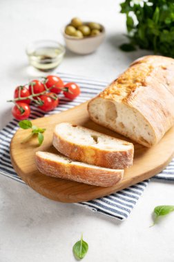 Beyaz arka planda domates, fesleğen ve zeytinli taze İtalyan ciabatta ekmeği dilimleri. Resmi kapat.