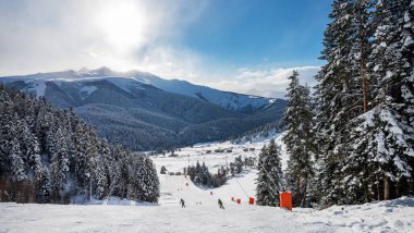 Güneşli bir kış gününde dağları, karı, ormanı, kayakçıları ve snowboardcuları olan Arkhyz kayak merkezinin güzel manzarası. Kafkas Dağları, Rusya.