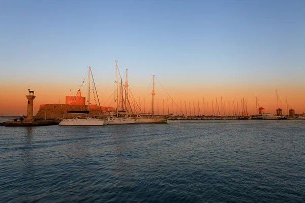 Rodos port i wiatraki w Grecji na zachodzie słońca — Zdjęcie stockowe