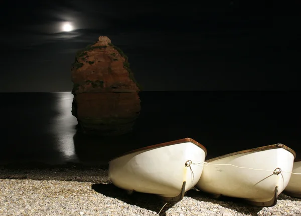 Måne över vatten på ladram bay — Stockfoto