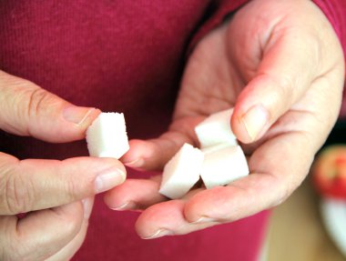 Sugar cubes in the hands of her grandmother clipart