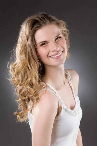 Portrait de jeune femme blonde souriante, haut blanc — Photo