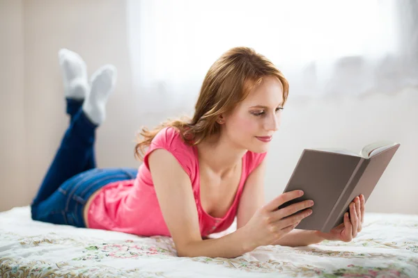 Relaxing woman reading book with a smile — Stock Photo, Image