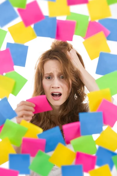 Femme stressée avec note entourée de papiers — Photo