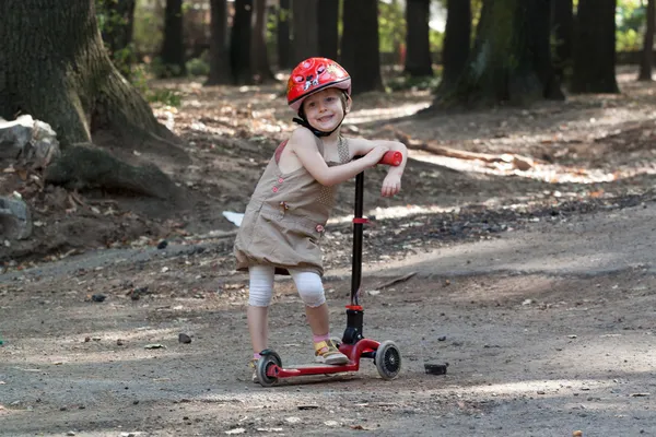 Petite fille avec scooter dans le parc — Photo