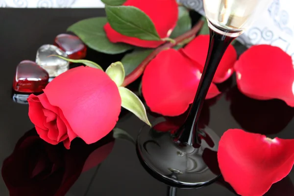 Beautiful red rose, glass of wine and rose leaves — Stock Photo, Image