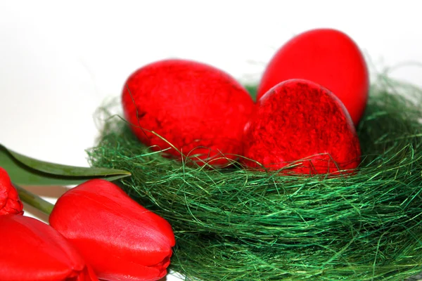 Red Easter eggs and red tulips bouquet — Stock Photo, Image