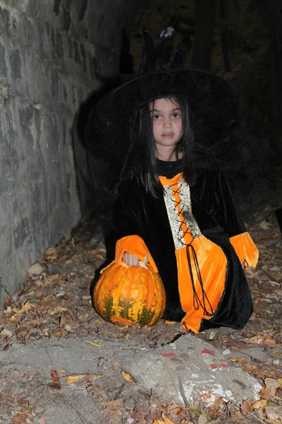 Witch child with a pumpkin in Halloween eve — Stock Photo, Image